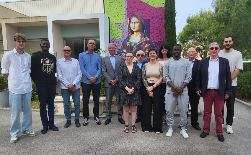 L'ensemble des participants devant la fresque réalisée par les apprentis du centre.